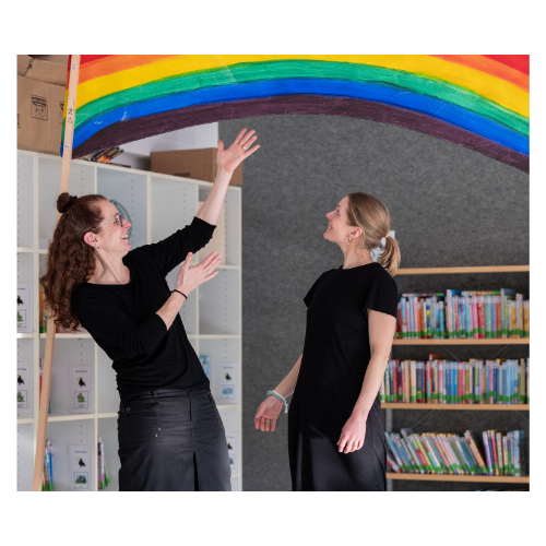 Julia Boskovic und Katrin Schneckenburger stehen. unterm Regenbogen